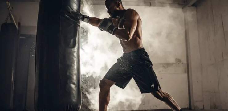 Məşq: Boksçu güclü zərbə ilə boks torbasını vurur